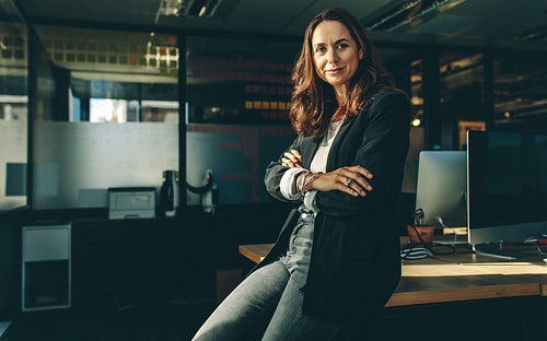 Mature businesswoman sitting on her desk
