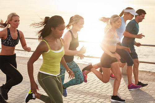 Portrait of a healthy young men and women running by the sea