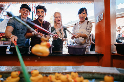 Excited young people playing fishing game