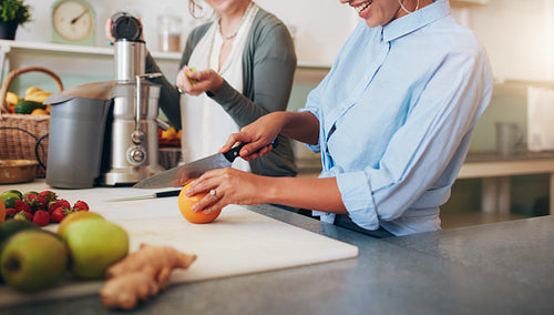 Women at bar counter preparing juice