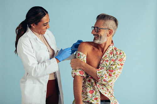 Doctor giving vaccination to mature man