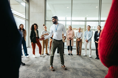 Team leader conducting a briefing with a diverse group in a modern office setting