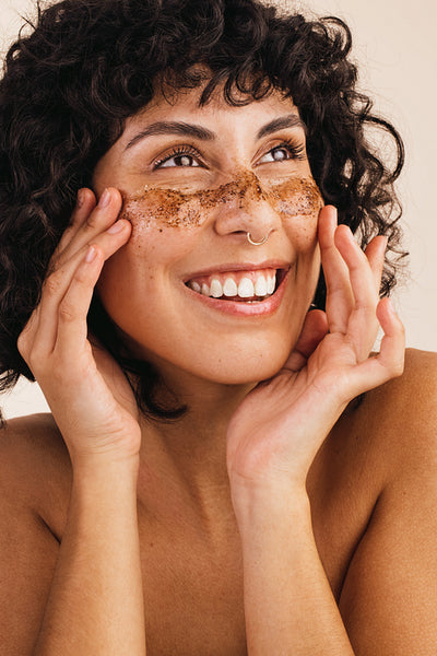 Woman exfoliating her skin with coffee scrub