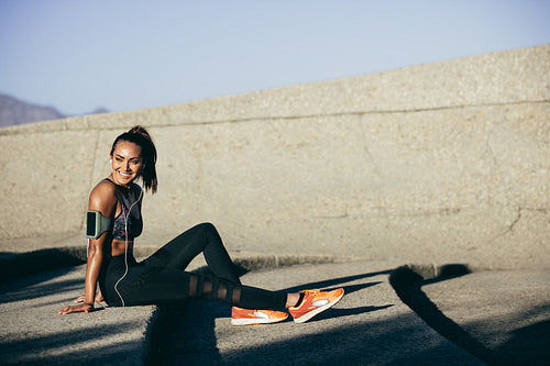Healthy woman sitting on steps after exercising