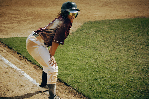 Young baseball player in action preparing to run bases at a dusty field in the warm sunshine