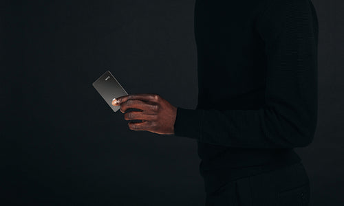 Professional man holding an exclusive credit card in a studio