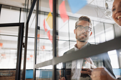 Businessman with colleague looking at adhesive notes
