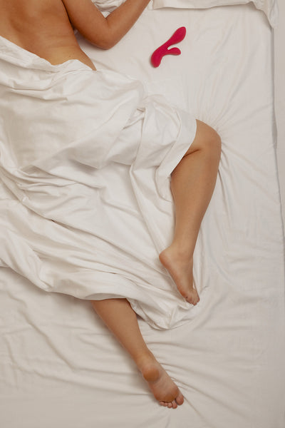 High angle view of a woman indulging in self-pleasure with an adult toy, fulfilling her intimate bedroom fantasies