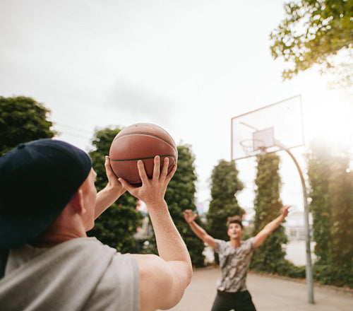  Friends playing basketball against each other