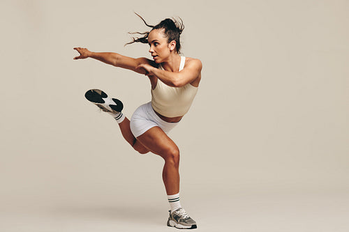 Fit woman working out with intense training moves in a studio