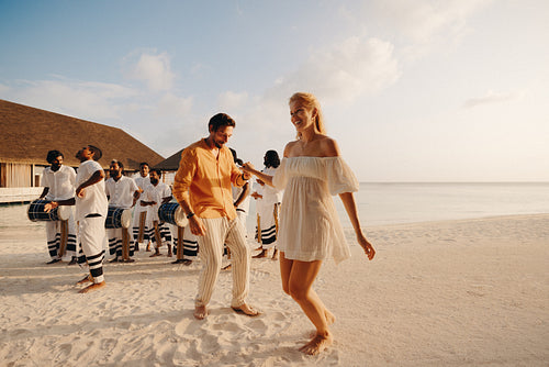 Couple enjoying vibrant entertainment at a beachfront resort holiday