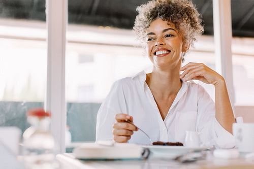 Happy mature woman looking away with a smile in a cafe