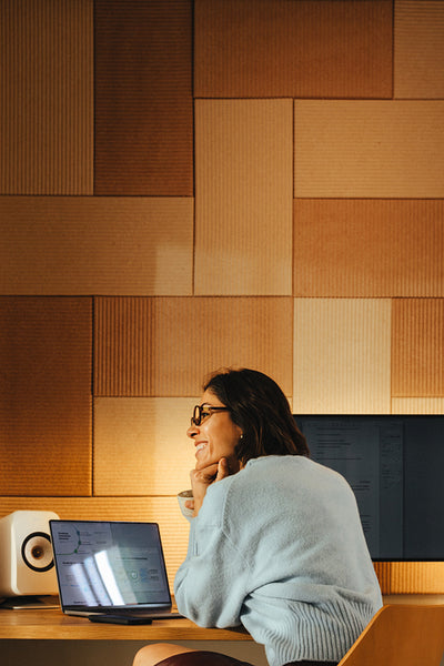 Woman works on a laptop at an office desk in a home office
