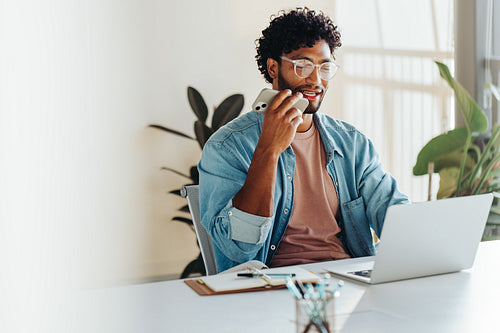 Young entrepreneur having a conversation on a phone call in his office