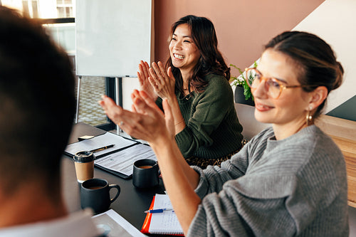 Happy businesspeople applauding during a meeting