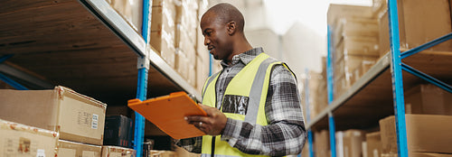 Black warehouse manager doing stock control