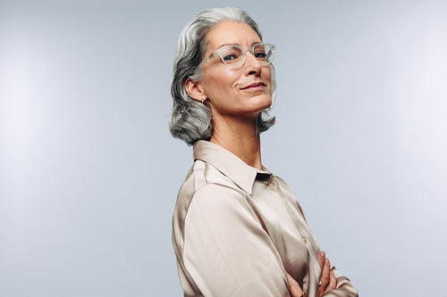 Confident older woman standing with arms crossed