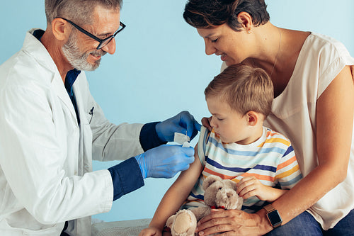 Boy getting vaccinated by doctor