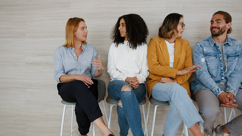 Expert discussion: Diverse panel of business professionals sit and talk in an office