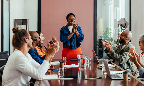 Business team rejoicing in boardroom during successful meeting presentation, celebrating partnership cooperation and victory with applause