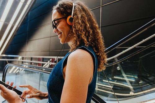 Commuting with smartphone and headphones on an urban escalator