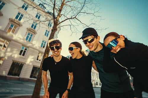 Running friends socializing outdoors in city after group fitness workout