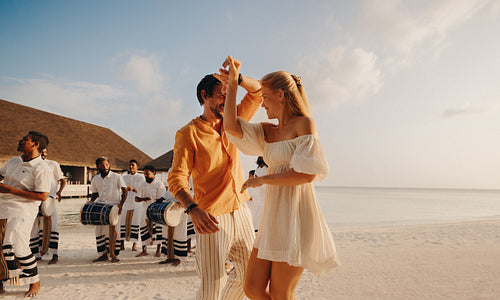 Newlyweds dancing on a tropical beach during a luxury vacation