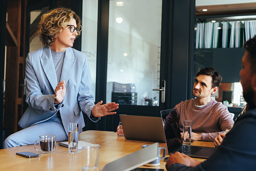Female team leader having a discussion with her colleagues in a meeting