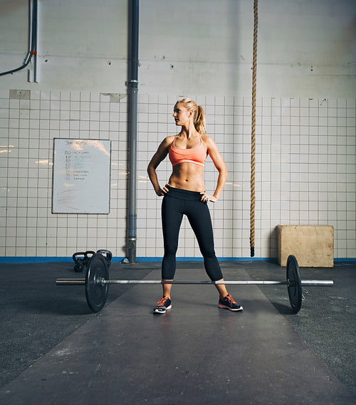 Fit young woman at gym with barbell