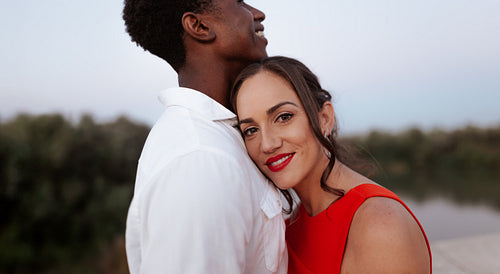 Woman leaning on her boyfriend's chest outdoors