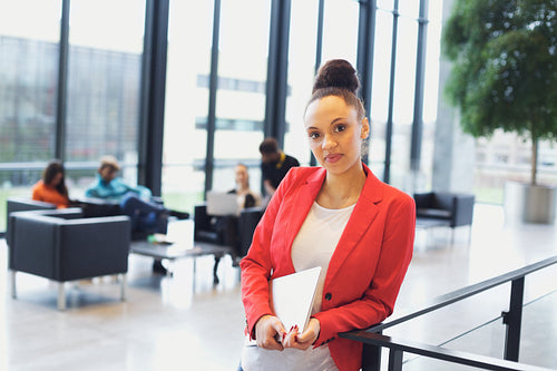 Confident young businesswoman with a laptop in office