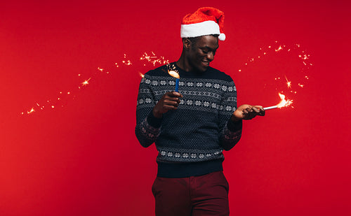African man enjoying christmas with fireworks