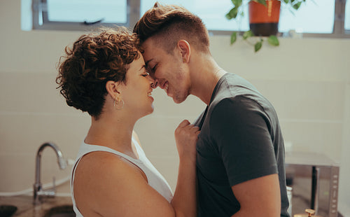 Affectionate queer couple being romantic at home