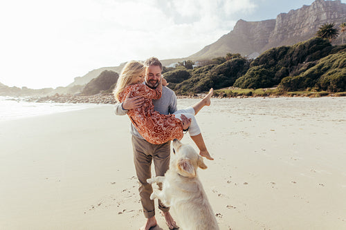 Romantic mature couple with a dog on the beach