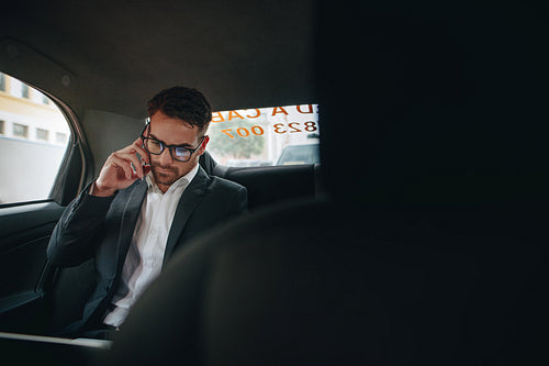 Businessman doing office work while travelling to office in a cab
