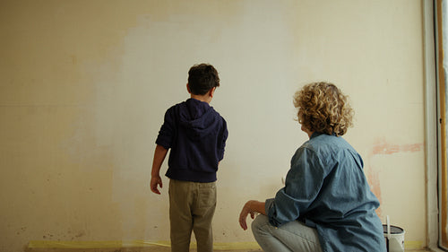 Small hands, big help: Son assists with painting the hallway