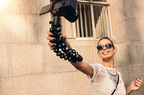 Young tourist recording selfie video while walking in the street.