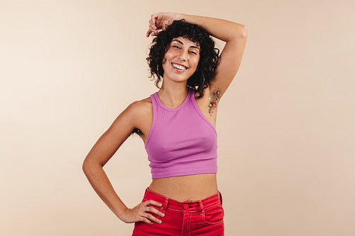 Cheerful young woman showing her decorated underarm hair