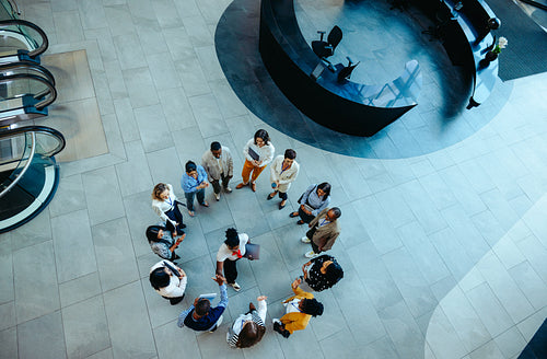 Overhead view of diverse group handshake in modern office lobby