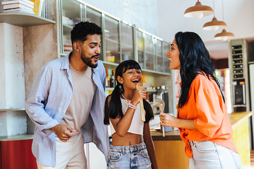 Latin American family singing and enjoying time together in the kitchen