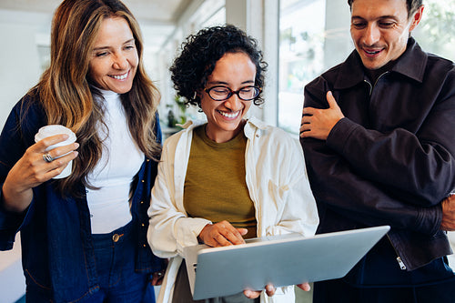 Team collaboration around a laptop in modern office