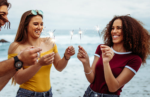 Multi-ethnic group of people with sparklers at the beach