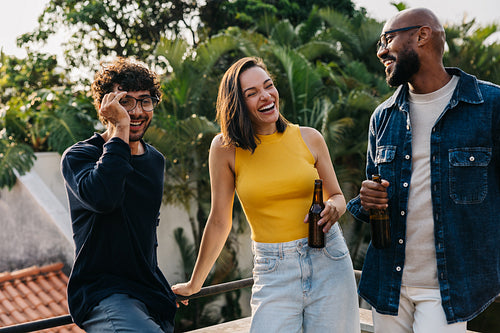 Diverse friends and colleagues enjoying drinks outdoors together