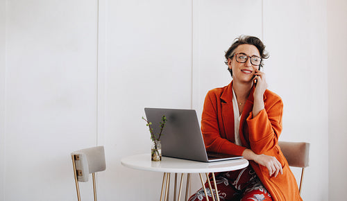 Mature business woman making a phone call while working in a cafe
