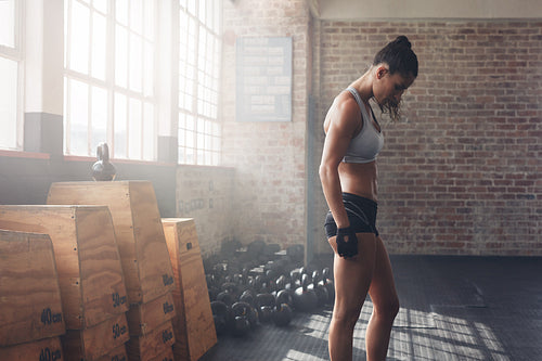 Muscular female athlete standing at the gym