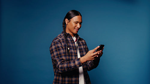 Young man taking selfies and texting on his phone