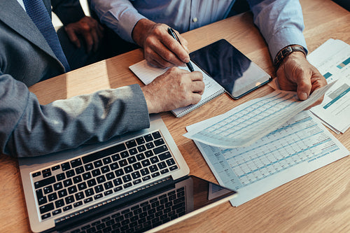 Business people analysing financial reports at cafe