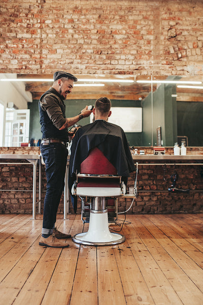 Hairdresser giving haircut to client at salon