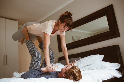 Couple having fun playing on bed at home