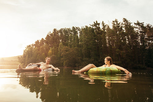 Young couple in lake on inflatable ring